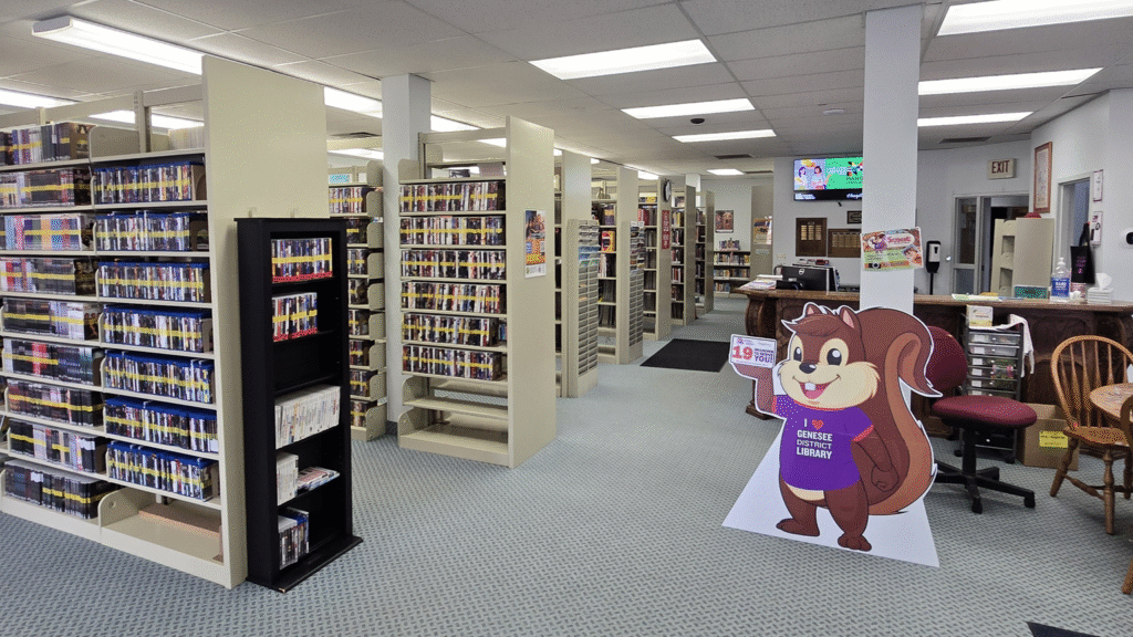 The inside of the Forest Township library with shelves of books and DVDs, and the circulation desk.