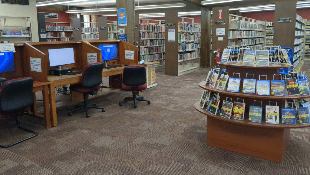 The inside of the Davison library, with computers, a display table of DVDs, and shelves of books