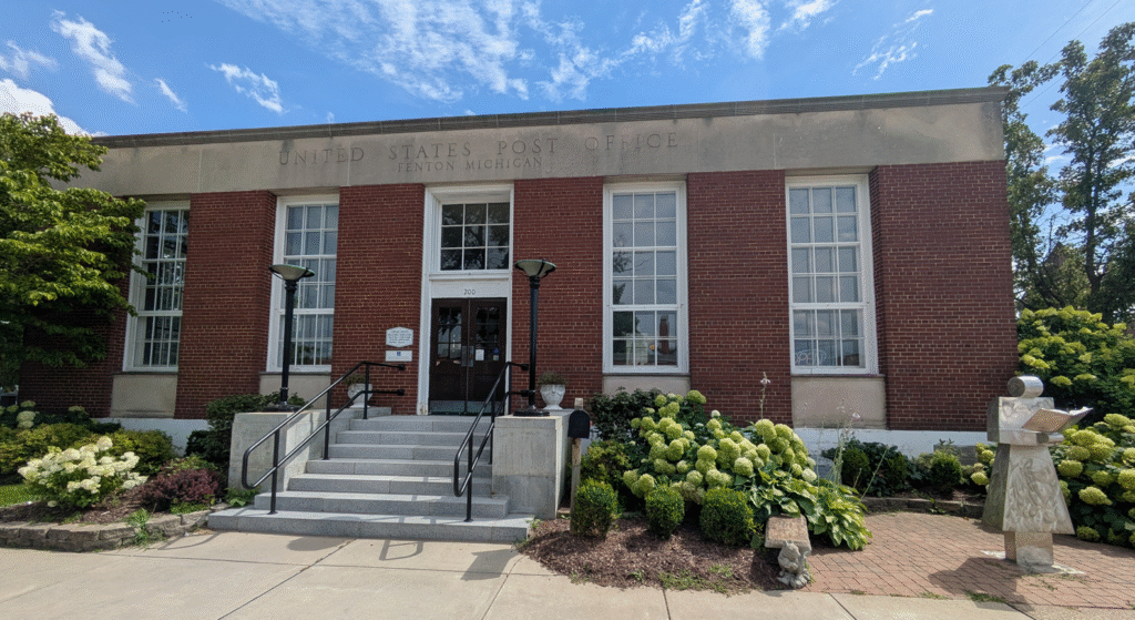 Outside of the Fenton-Winegarden Library with a Librarian Statue near the entrance.