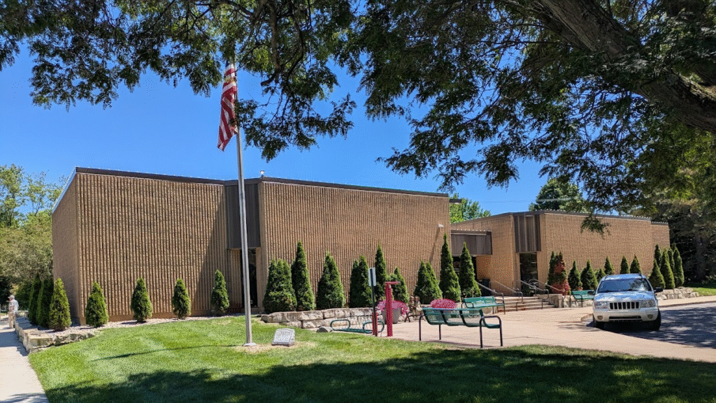 The outside of the Grand Blanc-McFarlen Library. Stairs at one entrance, a ramp at the back entrance.