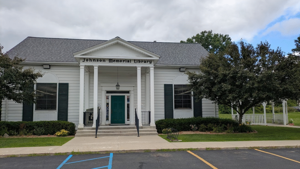 A white building with the text Johnson Memorial Library above the door. A gazebo next to the building