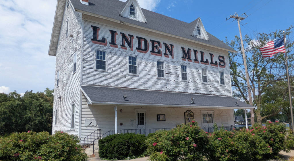 Outside view of the Linden Library, a multistory building with Linden Mills printed on the front in large letters.