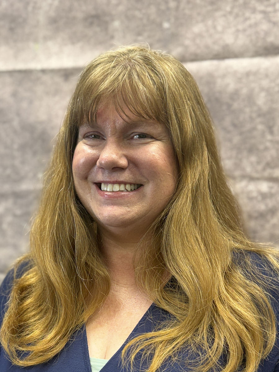A headshot of the librarian smiling